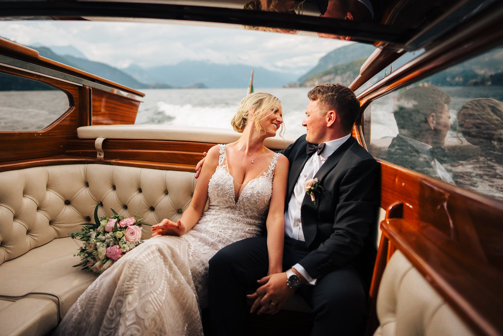 Bride and groom crossing an Italian lake by boat