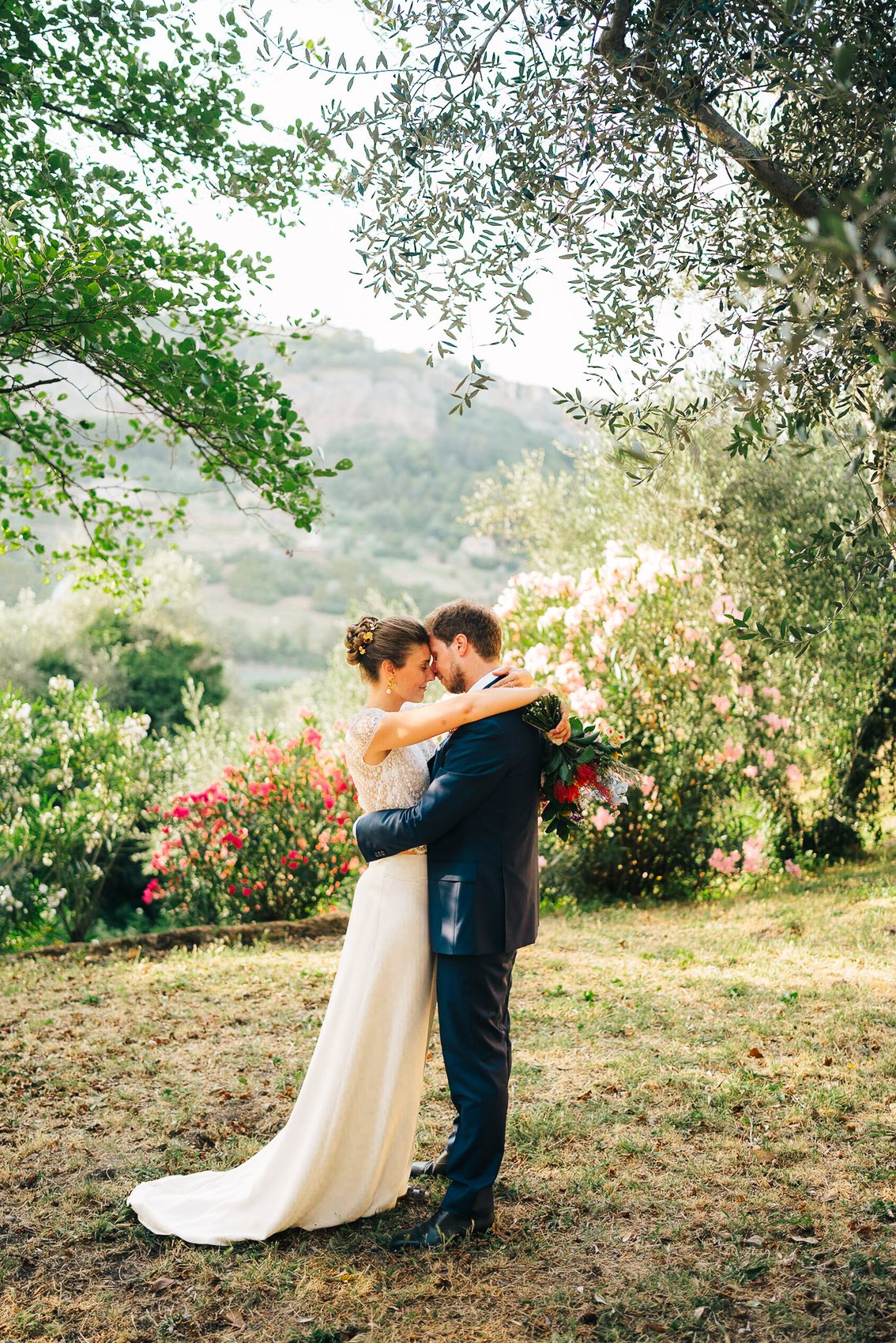 Bride and groom holding each other in an Italian garden