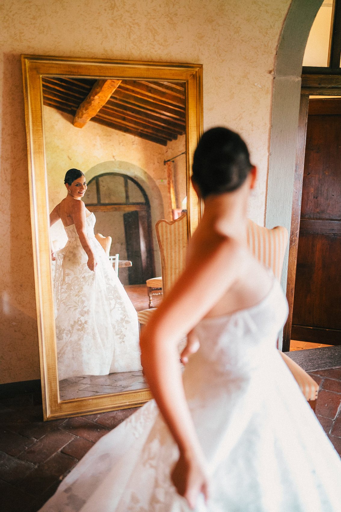 Bride looking at her dress in an Italian villa mirror
