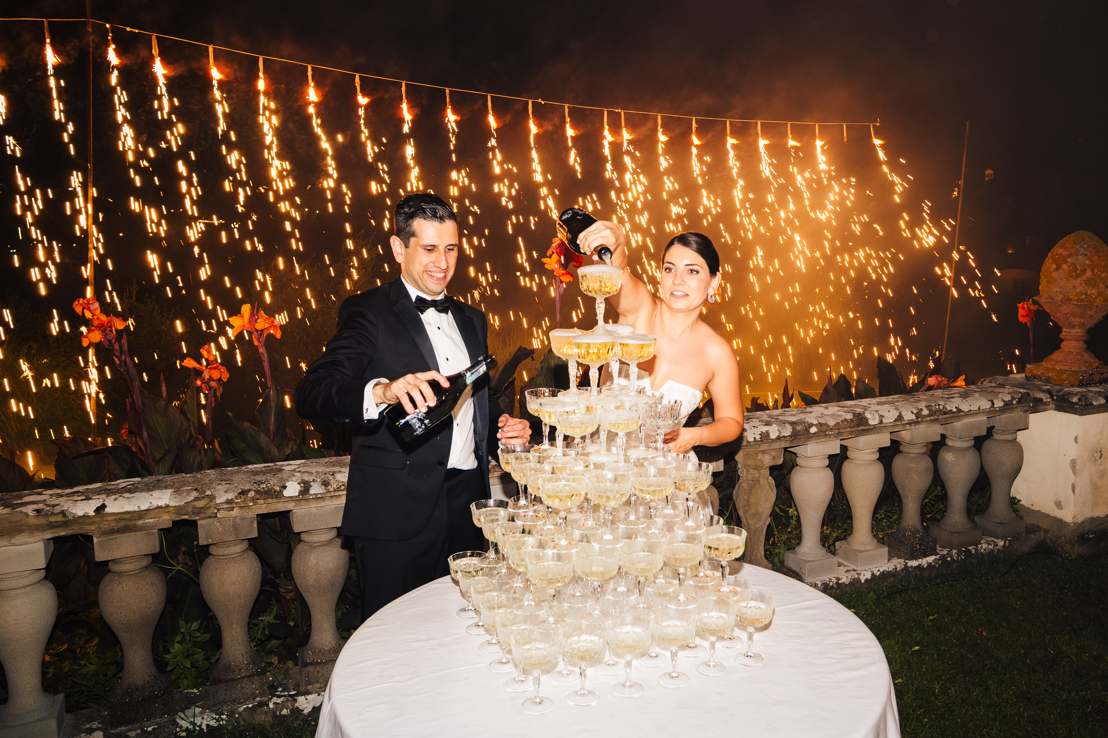 Bride and groom cutting a wedding cake under lights